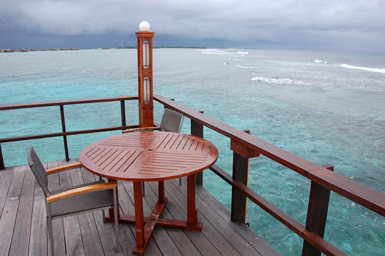 Table and chair at open air cafe with ocean view