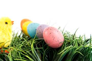 colored Easter eggs and yellow chick on grass