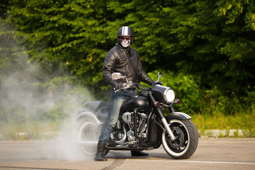 biker staying with unknown big chopper bike on road with smoke o