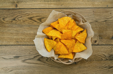 tortilla chips in basket on wooden surface