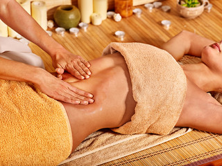 Woman getting massage in bamboo spa.