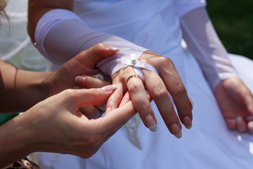 Bridesmaid helps the bride with a wedding ring