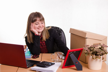 Smiling office employee looks at the picture frame