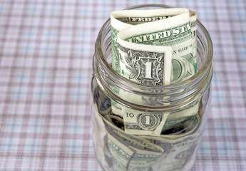 dollar bills in a glass mason jar
