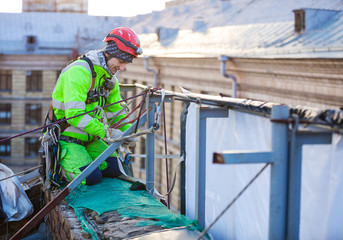 Fototapeta na wymiar Industrial climber on a roof of a building
