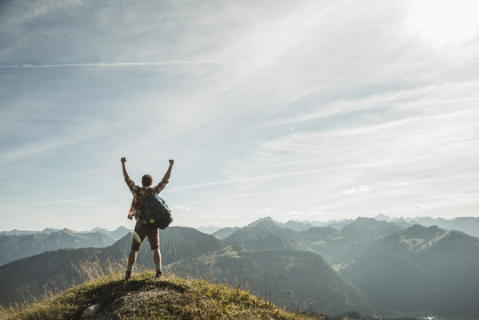 Austria, Tyrol, Tannheimer Tal, young man cheering on mountain top