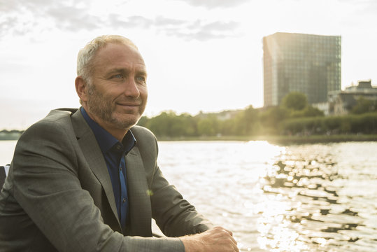 Germany, Frankfurt, relaxed businessman at river Main