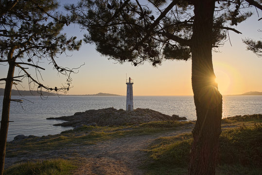 Spain, Galicia, Lighthouse at beach of Leis de Nemancos at sunset