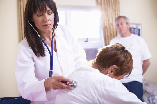 Doctor examining senior woman in hospital