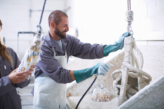 South Africa, Cape Town, Craftspeople preparing ceramic shell around casting mold