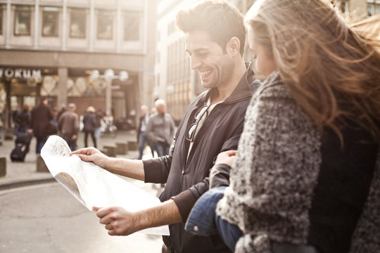 Germany, Cologne, young couple orientating with city map