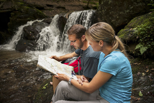 Germany, Rhineland-Palatinate, Moselsteig, Ehrbachklamm, couple reading map at waterfall