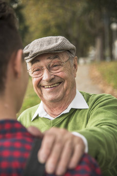 Senior man smiling at adult grandson