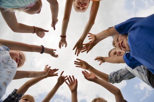 Germany, Bavaria, Group of children raising hands in air