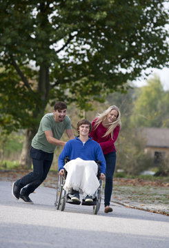 Young couple with friend sitting in wheelchair