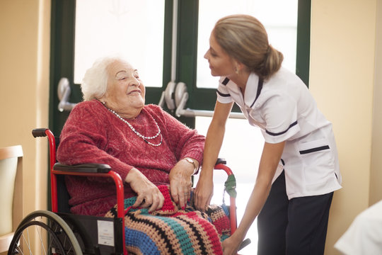 Nurse caring for senior woman in wheelchair