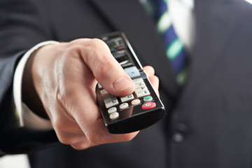 TV remote control in hand of businessman