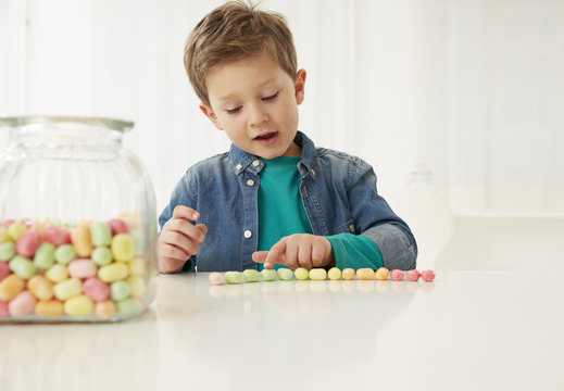 Germany, Munich, Boy with candy jar, counting candies