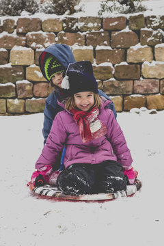 Two little girls sitting on a sledge