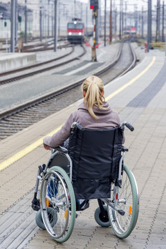 Woman in wheelchair waiting at station platform