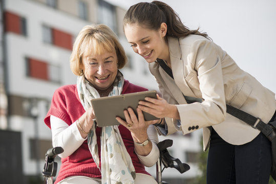 Granddaughter and her grandmother looking at digital tablet