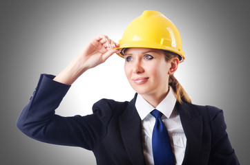 Young businesswoman with hard hat on white