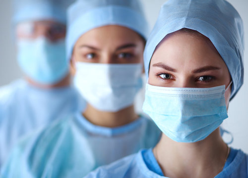 Surgeons Team, Wearing Protective Uniforms,caps And Masks