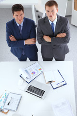 Two businessmen standing with a blank sheet of paper