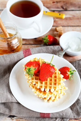 Waffles with strawberries and sweet black tea