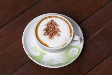 Coffee cup resting on a wooden table.