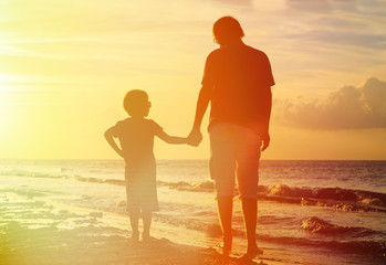 Fototapeta na wymiar father and son holding hands at sunset