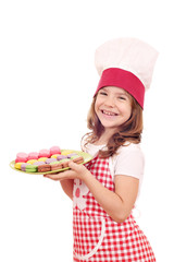 happy little girl cook hold plate with macarons