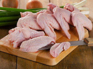 Uncooked  chicken wings on   wooden board