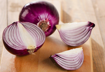 Fresh red onions on  a wooden board
