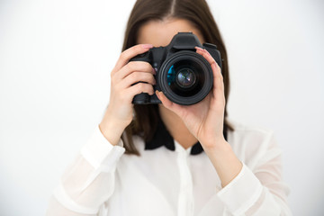 Female photographer with camera over gray background