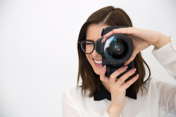Naklejka premium Smiling female photographer with camera over gray background