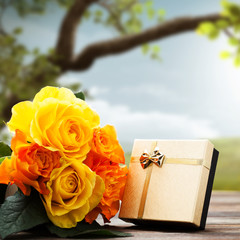 Rosen und Geschenkbox vor Frühlingshintergrund