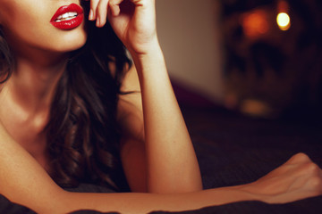 Sexy woman with red lips on bed closeup