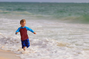 Fototapeta na wymiar happy little boy running on summer beach