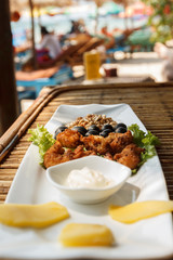 Squid tempura snack on plate on bamboo table