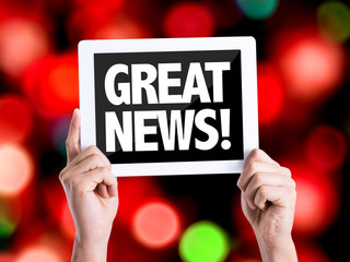 Tablet pc with text Great News with bokeh background