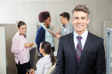 Happy Manager With Employees Discussing In Background