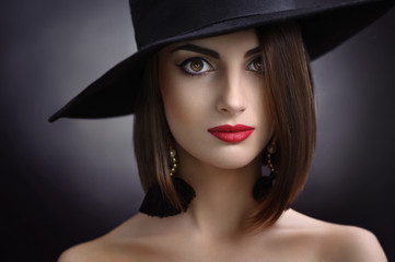beautiful girl with makeup in hat and earrings