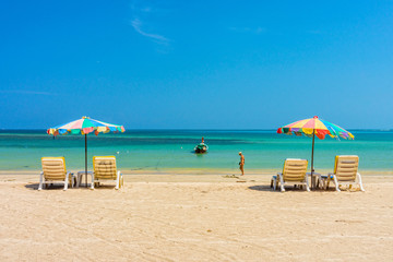Beach umbrellas and sunbathe seats on Phuket sand beach in South