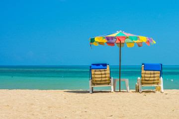 Beach umbrellas and sunbathe seats on Phuket sand beach in South