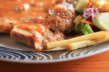 Steaks, pork, french fries with salad.