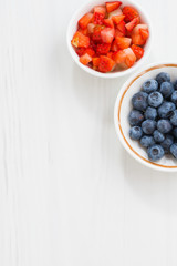 fresh berries - blueberries and sliced strawberries on white