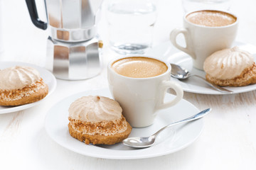 fresh cappuccino and cakes on white wooden table