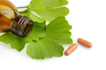 Ginkgo biloba leaves and medicine bottles with pills isolated