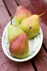 Ripe sweet pear lying on a white plate